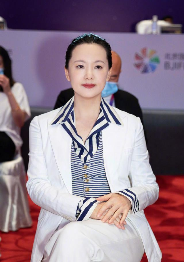 全球时尚号|51岁的咏梅去国外旅游，穿米色大衣霸气十足，撑着伞在雨中漫步