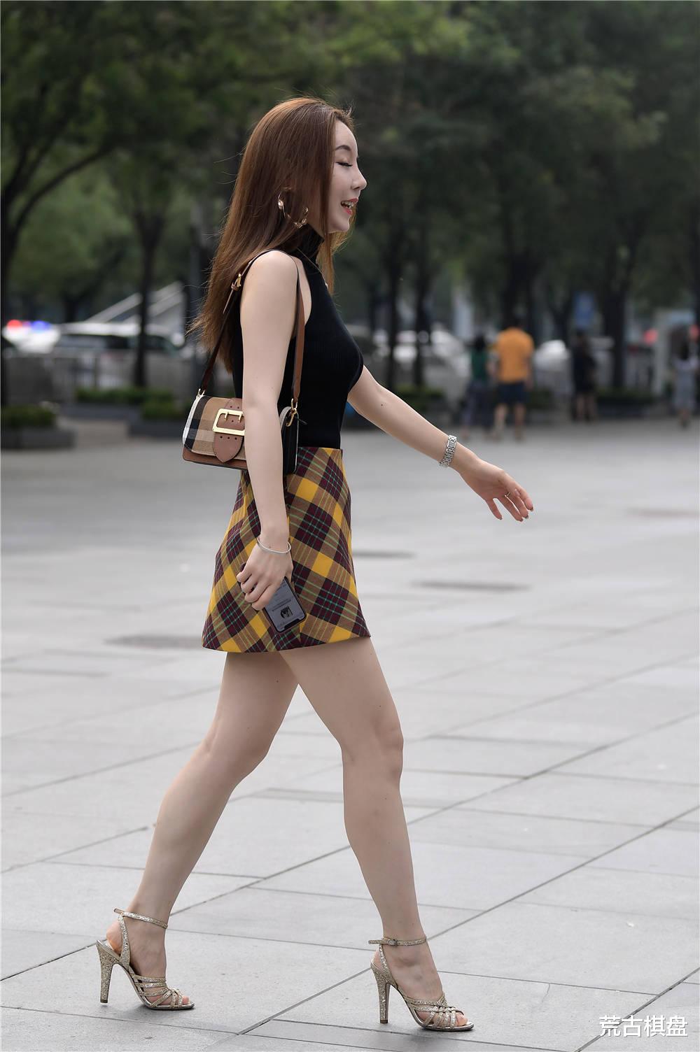 荒古棋盘|黄黑色格子短裙，搭配高领无袖衬衫，细跟凉鞋更显瘦