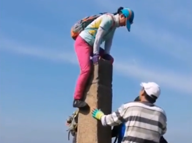 悦姐ya|辽宁一大姐不顾危险站在崖壁石柱上拍照，网友直呼：看得腿都发麻