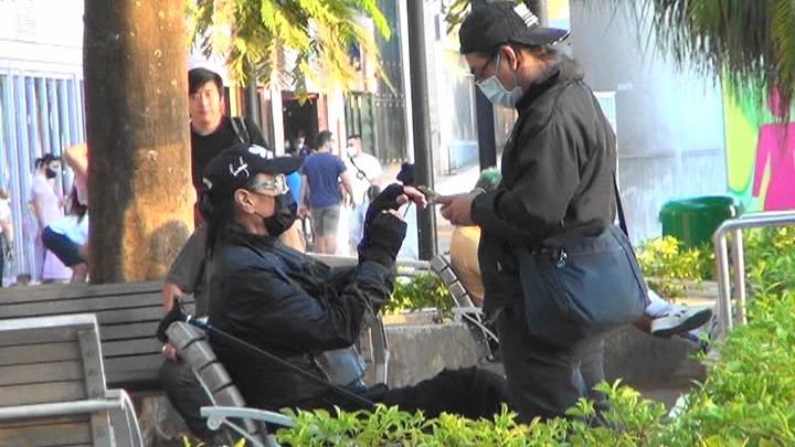 |85岁谢贤拄拐杖逛商场,体力不济由男助手搀扶,走路不稳险摔倒