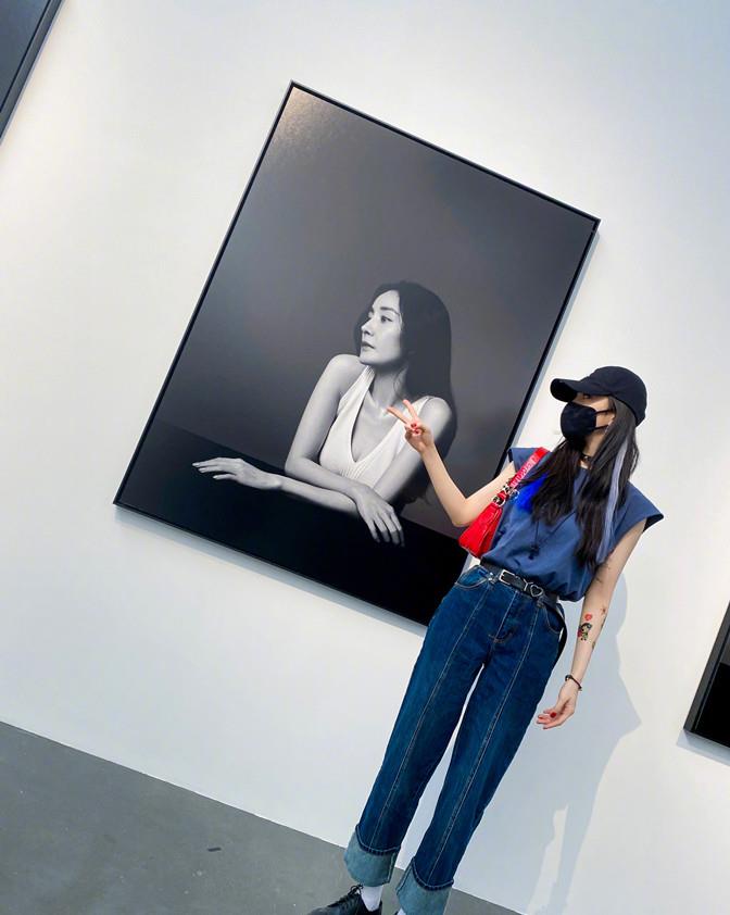 方脸妹说时尚|杨幂遛弯看展真悠闲，穿无袖反手大花臂抢镜，见自己海报俏皮合拍