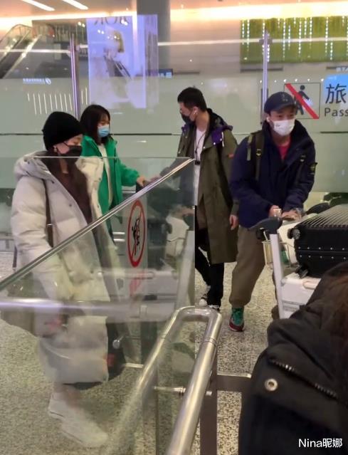 张靓颖|张靓颖罕携男友赶飞机！穿羽绒服内搭露脐装不怕冷，小男友推行李真爷们