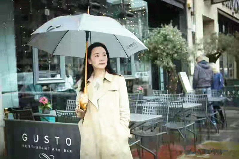 全球时尚号|51岁的咏梅去国外旅游，穿米色大衣霸气十足，撑着伞在雨中漫步