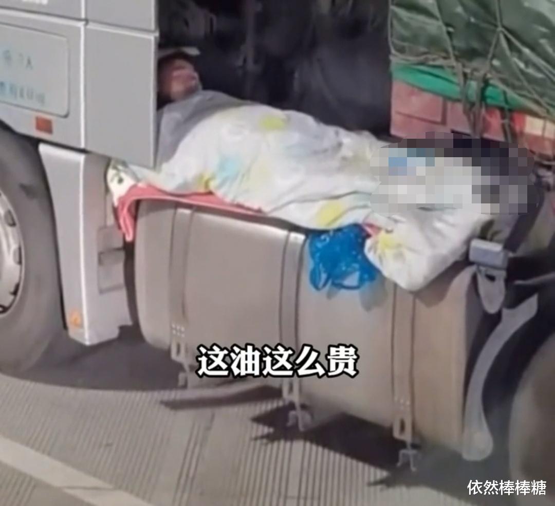 好心酸:货车司机服务区内在油箱上面打铺盖睡觉