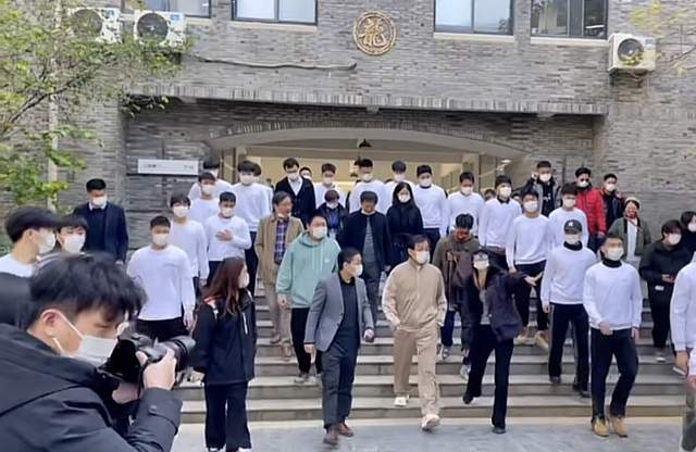 成龙|67岁成龙现身武汉高校上课，获百人迎接排场大，亲切打招呼无架子