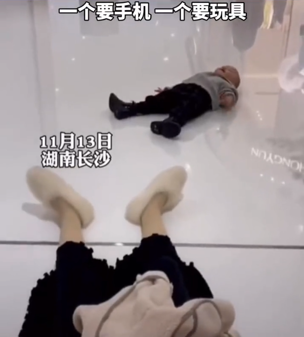 湖南一家三口逛商场,母子俩竟睡地上撒娇:一个要玩具一个要手机