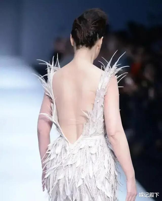 周海媚|50岁周海媚不服老，穿肉色羽毛长裙走秀，虎背熊腰被全网嘲笑