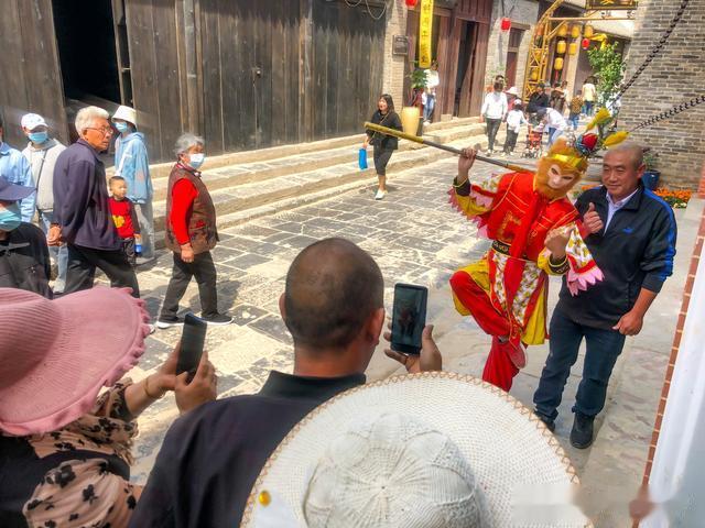 皖北农村视界 安徽淮北：“齐天大圣”耍“金箍棒”亮相濉溪古城街头与游客合影