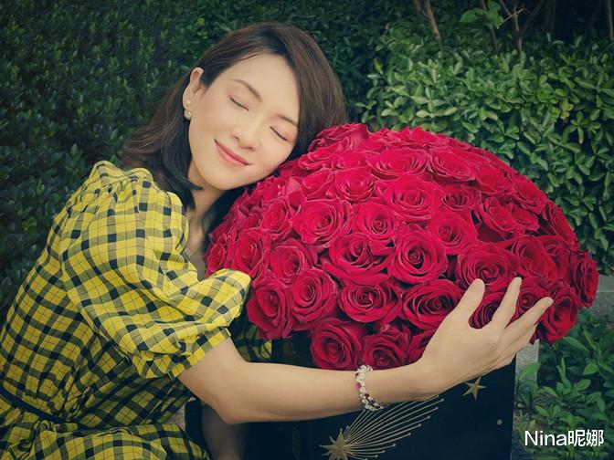 Nina昵娜|章子怡雨中撑伞看秀，穿透明雨衣踩短靴，坐C位抱小熊哪像俩娃妈