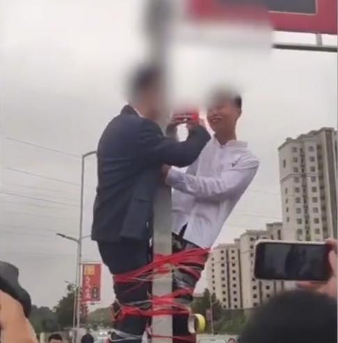 山东省 山东俩新郎被绑在杆子上喝交杯酒?知情人:接完新娘“撞喜”了