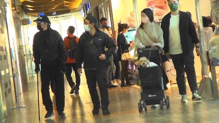 |85岁谢贤拄拐杖逛商场,体力不济由男助手搀扶,走路不稳险摔倒