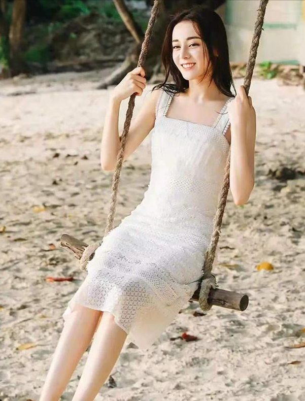 易烊千玺|迪丽热巴现身海边拍大片，身穿白色吊带裙荡秋千，网友：气质真好