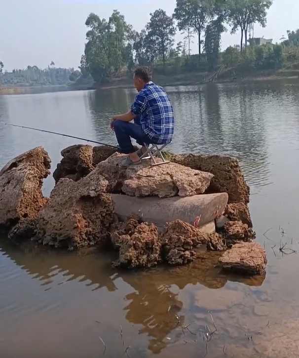 水库|?胆真大！男子竟坐在一口棺材上钓鱼！