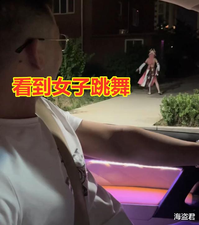 女子穿着清凉跳舞,昏暗路灯下布条飞扬,男子笑着吐槽:吓我一跳