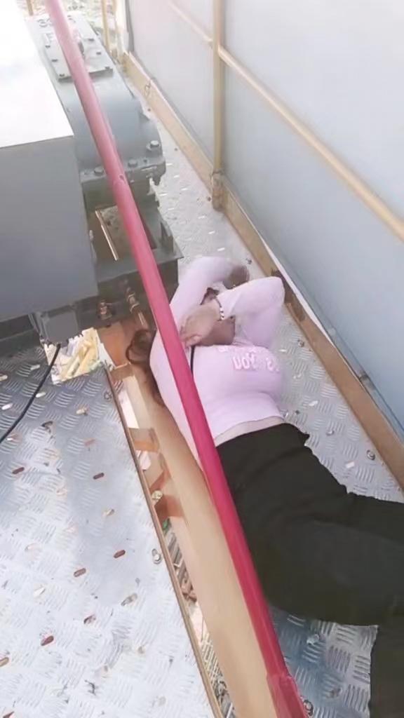 一女子上班时偷懒,趁着主管不在车间内,躺在机器旁边睡觉