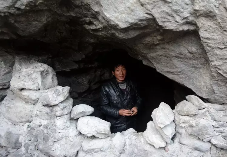 80岁老人自称儿子是富豪,整日住在山洞里,和十几条狗一起吃饭
