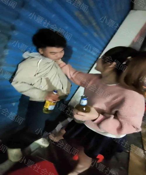 两名女孩把一名男孩灌醉，抓着他的衣领，要求他继续喝酒
