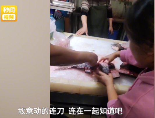 江苏无锡,一女子在鱼摊上买了一条鱼,然后让老板帮忙宰杀切块