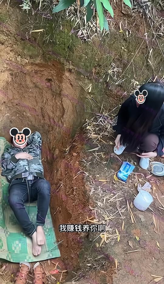 男子挖了个坑自己躺进去,妻子想劝他回家:以后我外出打工养你