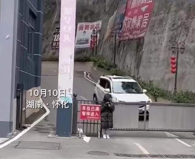 湖南女生在小区门口玩手机，小车从旁边经过，女生外套不翼而飞