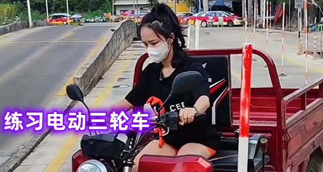 一名女子在江边练电三轮车,连人带车冲进水里