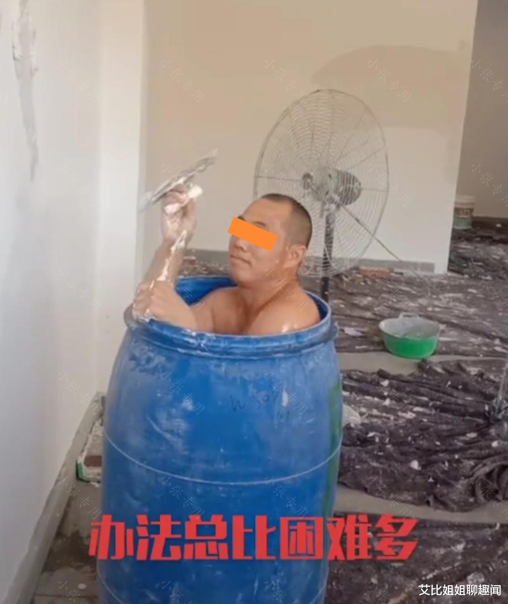 装修工人给涂料桶里装满凉水,自己站在水里帮人刷墙,以此来降温