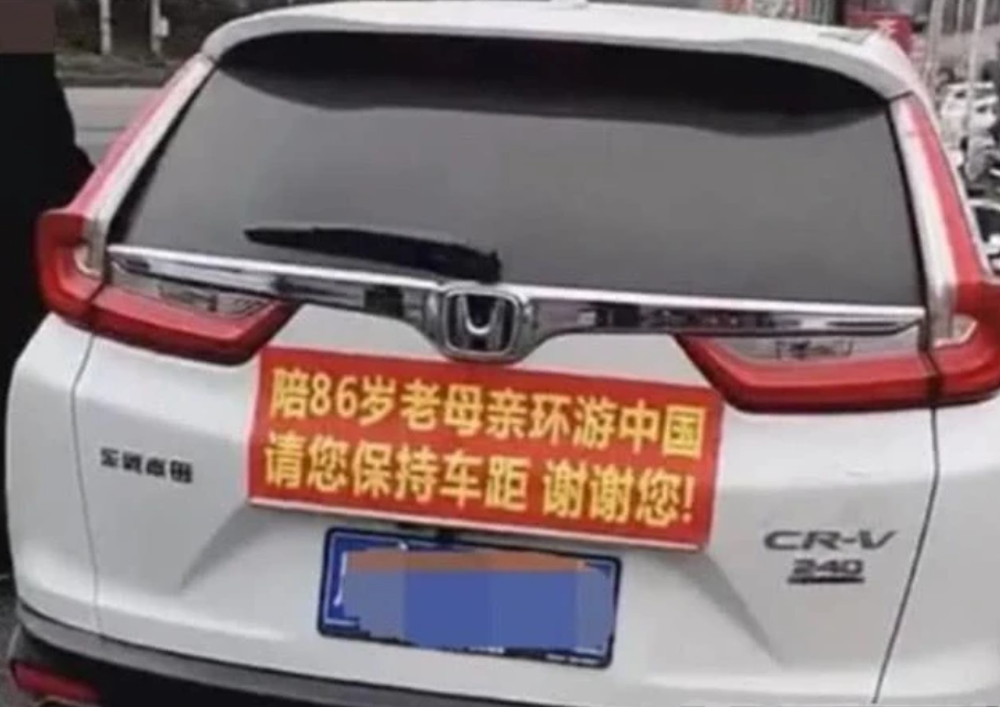 高速路上一辆白色小车,车尾拉一条横幅,走近一看,不忍心按喇叭