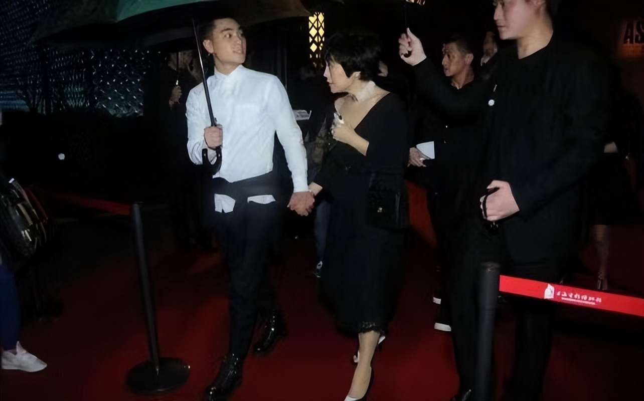 张艾嘉儿子可以出道了,外套拦腰系腰上看不懂,雨中牵妈妈很温柔