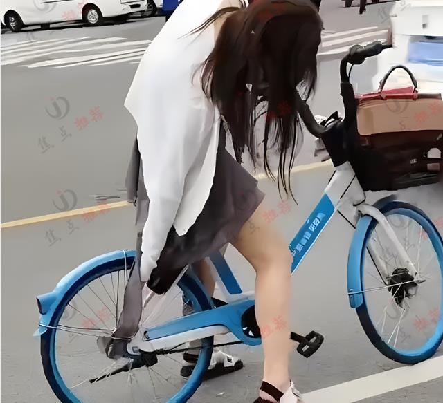 女子骑单车裙子卡住链条，旁边一群人排队却无人帮忙，让人心酸