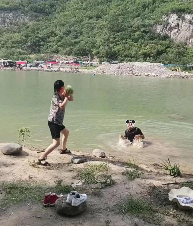 男子手持一瓶酒，坐在湖边和钓鱼的女子聊天，被老婆一脚踹到水里