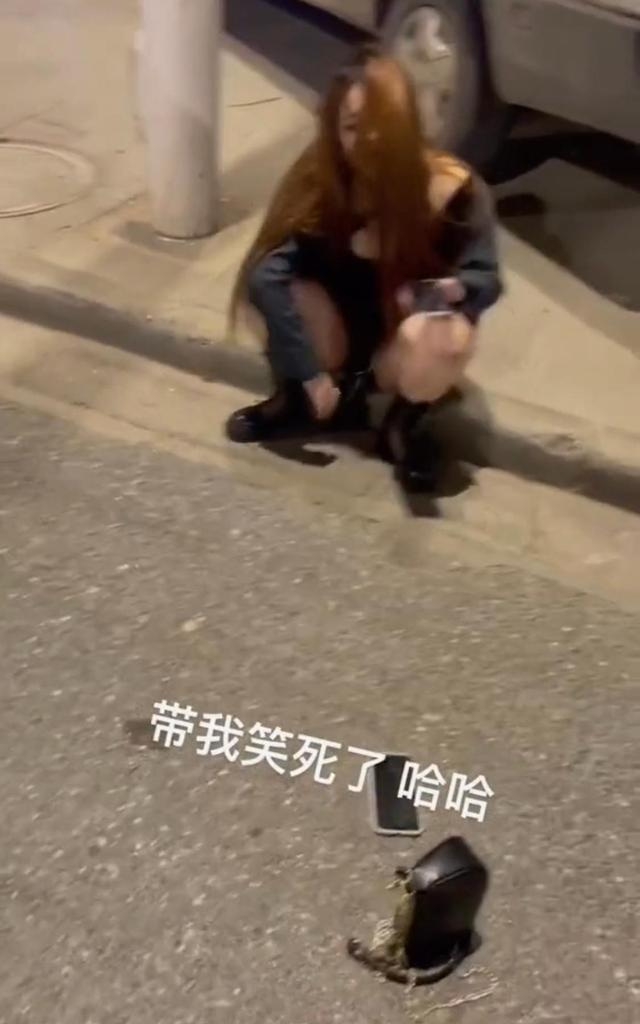 一名醉酒的女子,分不清东西南北,在马路边上爬来爬去