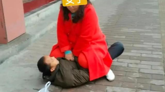 长沙街头，女子把男子按倒在地不让走要男子还钱。男子挣扎了好一会都没能够翻身