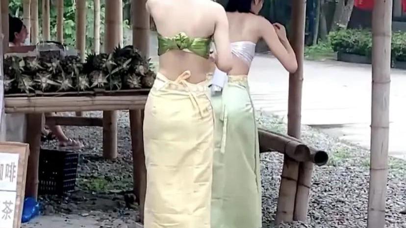 两女子景区仅穿胸衣吃水果，游客尴尬斜视