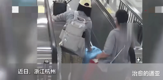 浙江杭州,一地铁进站口,一女子带着两个行李箱进站