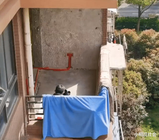 上海一装修工被封毛坯20天,独坐阳台晒太阳,男子隔空喊话送温暖