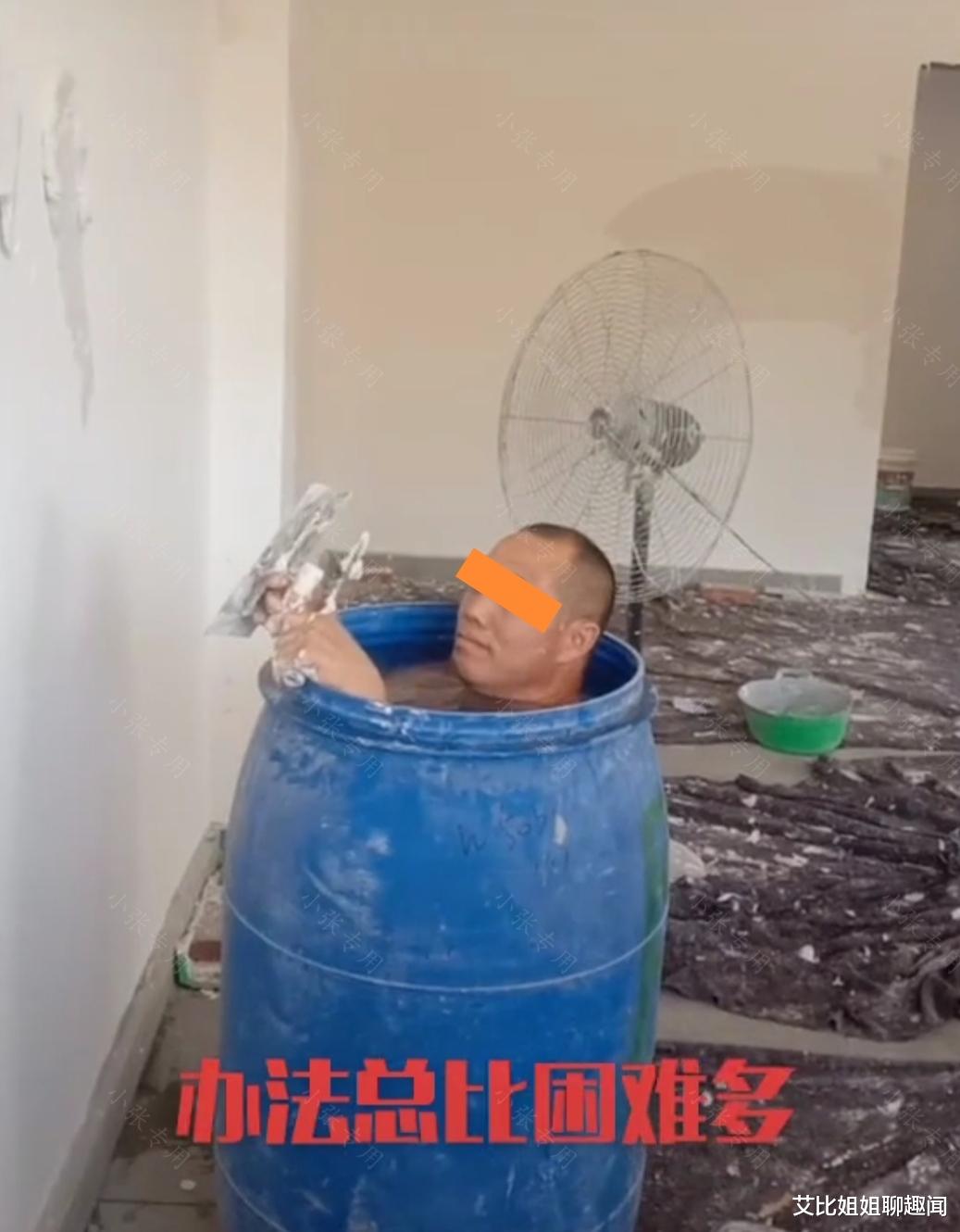 装修工人给涂料桶里装满凉水,自己站在水里帮人刷墙,以此来降温