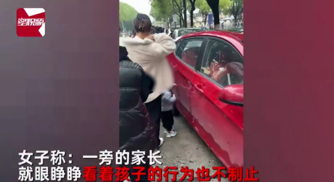 江苏一女子排队做核酸时,任由小孩拿钥匙划车,引发网友热议