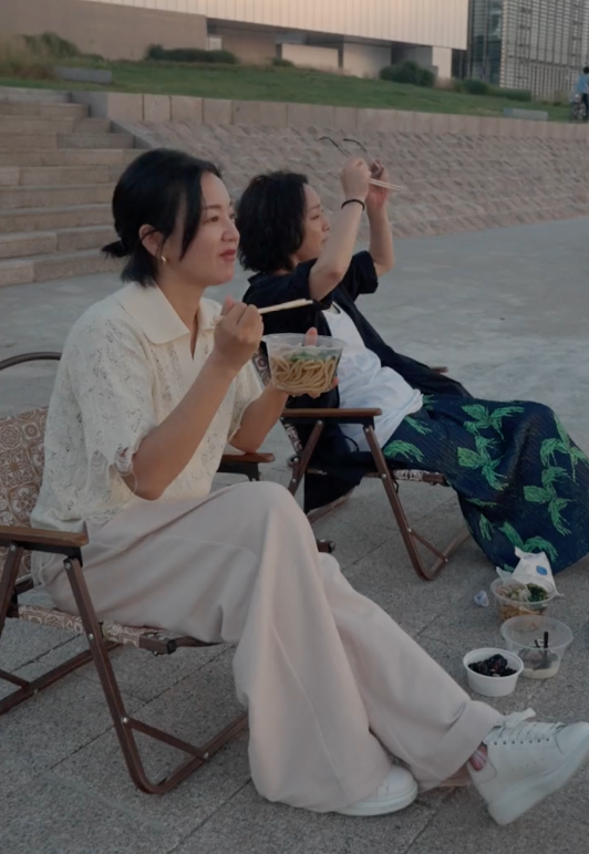 周迅|周迅阿雅坐江边大口嗦粉，地上摆4个外卖盒，穿花裤子打扮随性