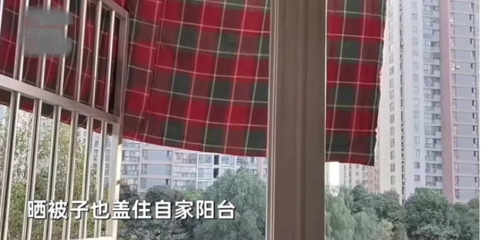江苏,住在楼下的女子看到楼上邻居正晾晒的地毯把自家阳台给遮住了