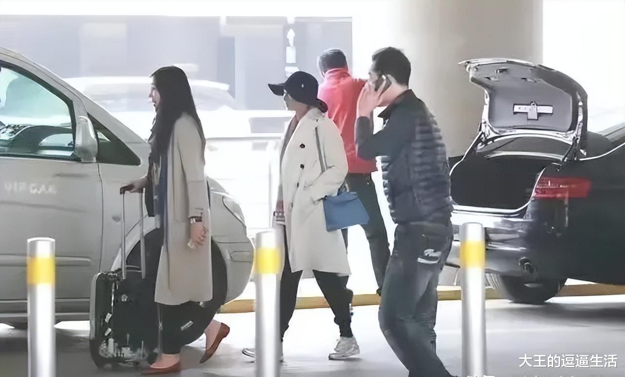 张艺谋|张艺谋娇妻独自现身机场!白色大衣气质优雅,戴宽檐帽时尚感十足