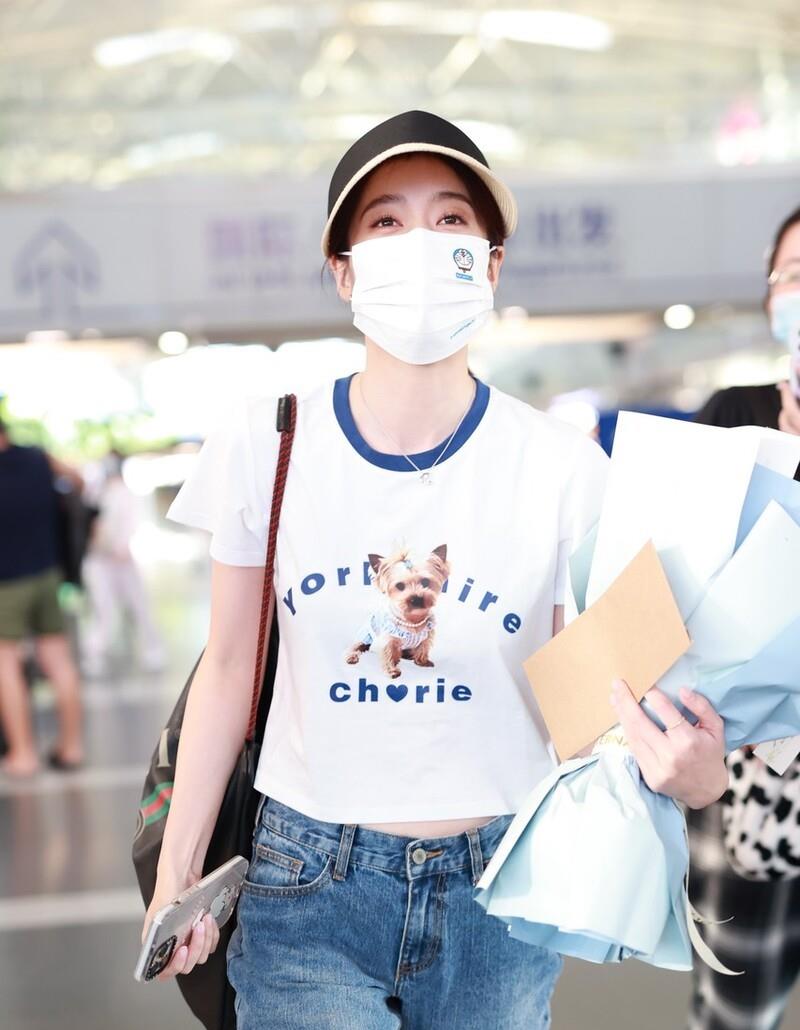 张雪迎|张雪迎穿小狗短袖牛仔裤现身机场，手捧鲜花人气旺