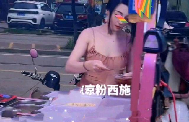 女子穿着吊带卖凉粉,很多男顾客驻足围观,站在一旁边吃边看