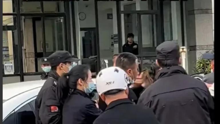 浙江温州，一名男子不顾众人劝阻，执意要殴打一年轻男子，现场十分混乱