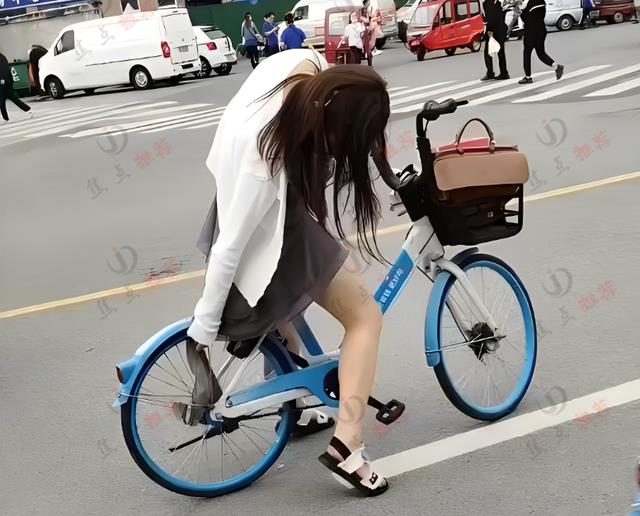 女子骑单车裙子卡住链条，旁边一群人排队却无人帮忙，让人心酸