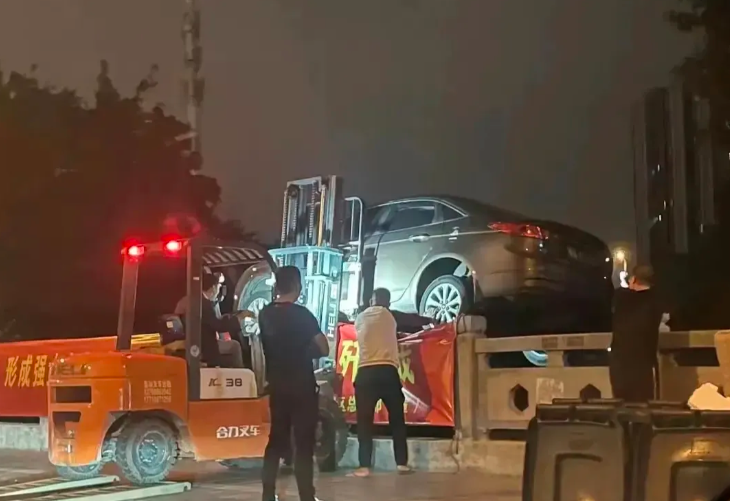 车位被占男子把占位车丢河里,要求移车被拒绝,暴怒之下花钱雇车推河里