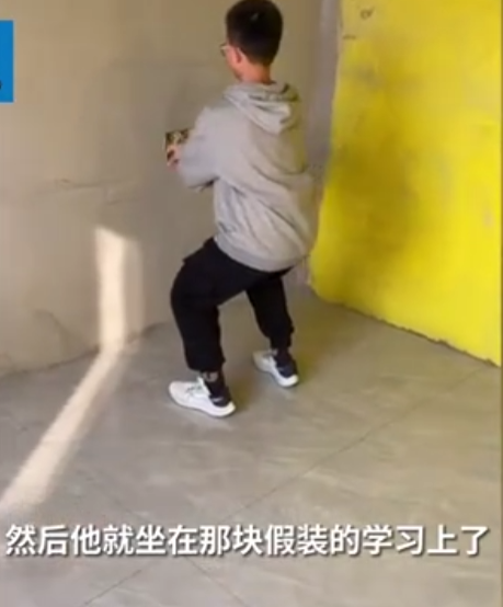 男孩在毛坯房间模拟学习的样子