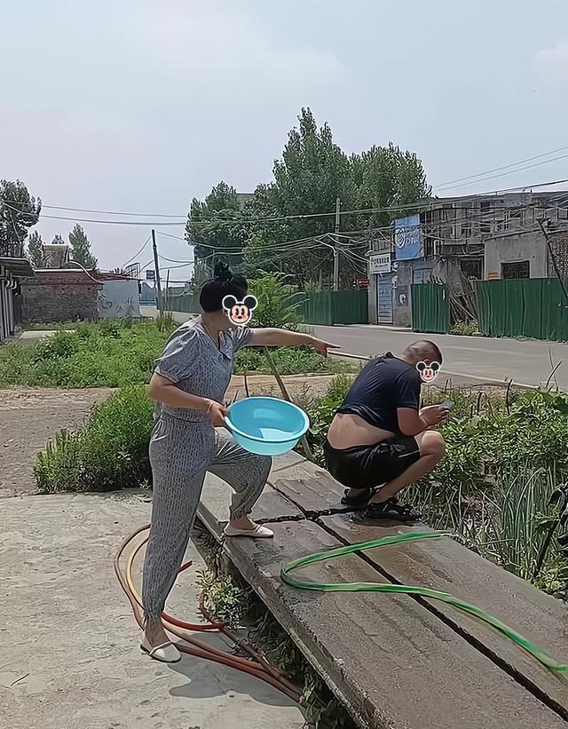 一女子让丈夫浇地,他却只顾玩手机,女子将水管插到他的裤子里