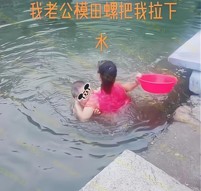 男子在水塘里摸田螺,妻子在岸上观看,他趁妻子不备把她拉下水