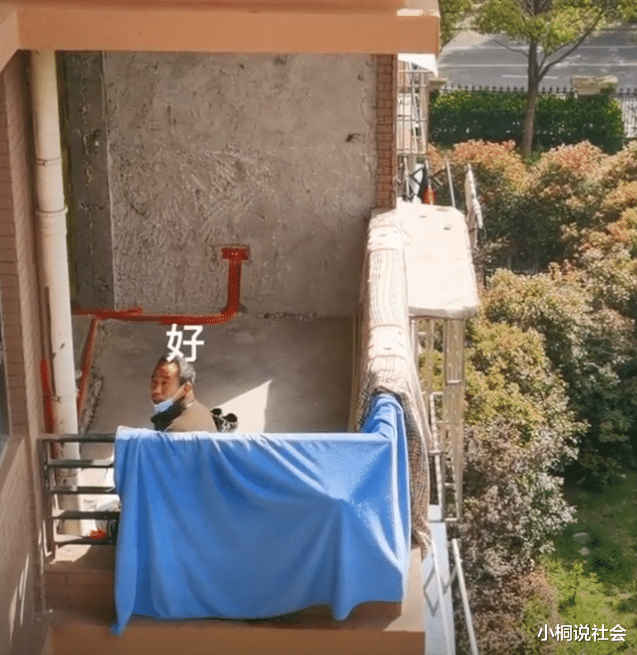上海一装修工被封毛坯20天,独坐阳台晒太阳,男子隔空喊话送温暖