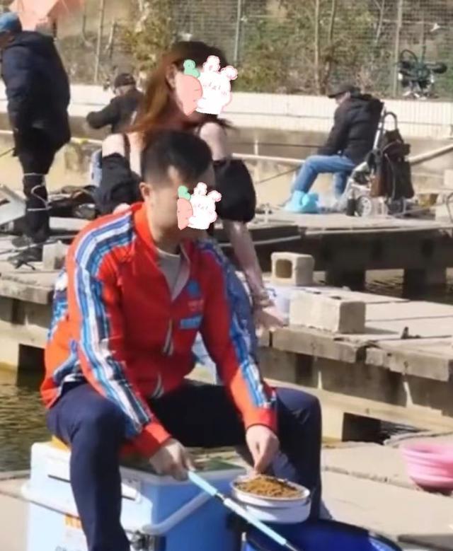|一女子，对一位忙着钓鱼的男子贴身热舞，男子却无动于衷